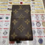 「伊勢佐木モール本店で査定されたルイヴィトンのモノグラム・シガレットケース。買取パンフレットの上に置かれたヴィトン小物の写真。」