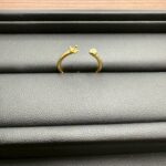 「黒いトレーの上に壊れて開いた状態のK18リングが置かれている写真」