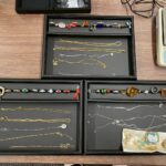 蒔田店で査定された大量の貴金属と宝石の写真。K18やプラチナのチェーン、エメラルド、アクアマリン、サンゴ、ダイヤモンドなど多種類のジュエリーが並び、高価買取に対応している様子を示す。