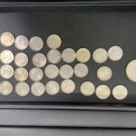 東京オリンピック記念などの100円銀貨が複数枚並べられている写真